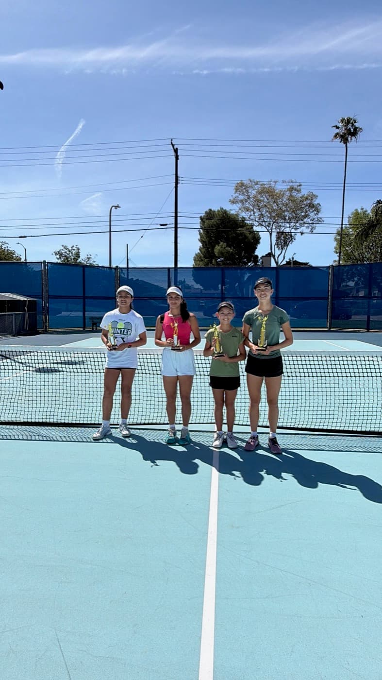 Four players holding tournament trophies
